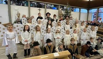 Eine große Kindergruppe steht als verkleidete Engel in der Erbshausener Kirche.