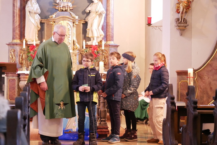 Pfarrer Rügamer und die Kinder sind im Altarraum der Hausener Kirche.