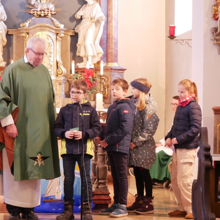 Pfarrer Rügamer und die Kinder sind im Altarraum der Hausener Kirche.