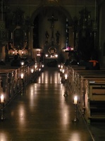 Blick von hinten auf den Altar, die Kirche ist nur mit Kerzen stimmungsvoll beleuchtet