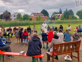 Blick auf eine Runde um ein Lagerfeuer auf dem Bolzplatz
