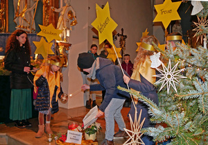 Kinder mit Sternen aus gelbem Papier agieren im Altarraum in der Hausener Kirche.