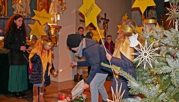 Kinder mit Sternen aus gelbem Papier agieren im Altarraum in der Hausener Kirche.