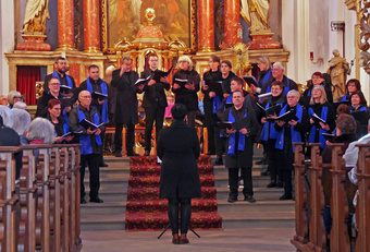 Auf den Altarstufen der Kirche steht ein Chor und singt