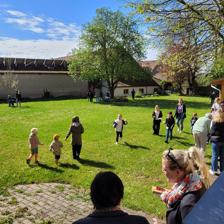 Blick auf einen großen Garten, in dem viele Kinder herumlaufen und Ostereier suchen