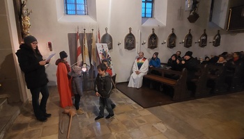 Kinder spielen die Legende von St. Martin in der Kirche nach.