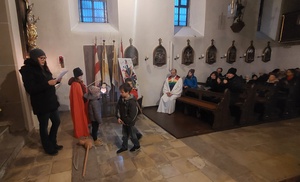 Kinder spielen die Legende von St. Martin in der Kirche nach.